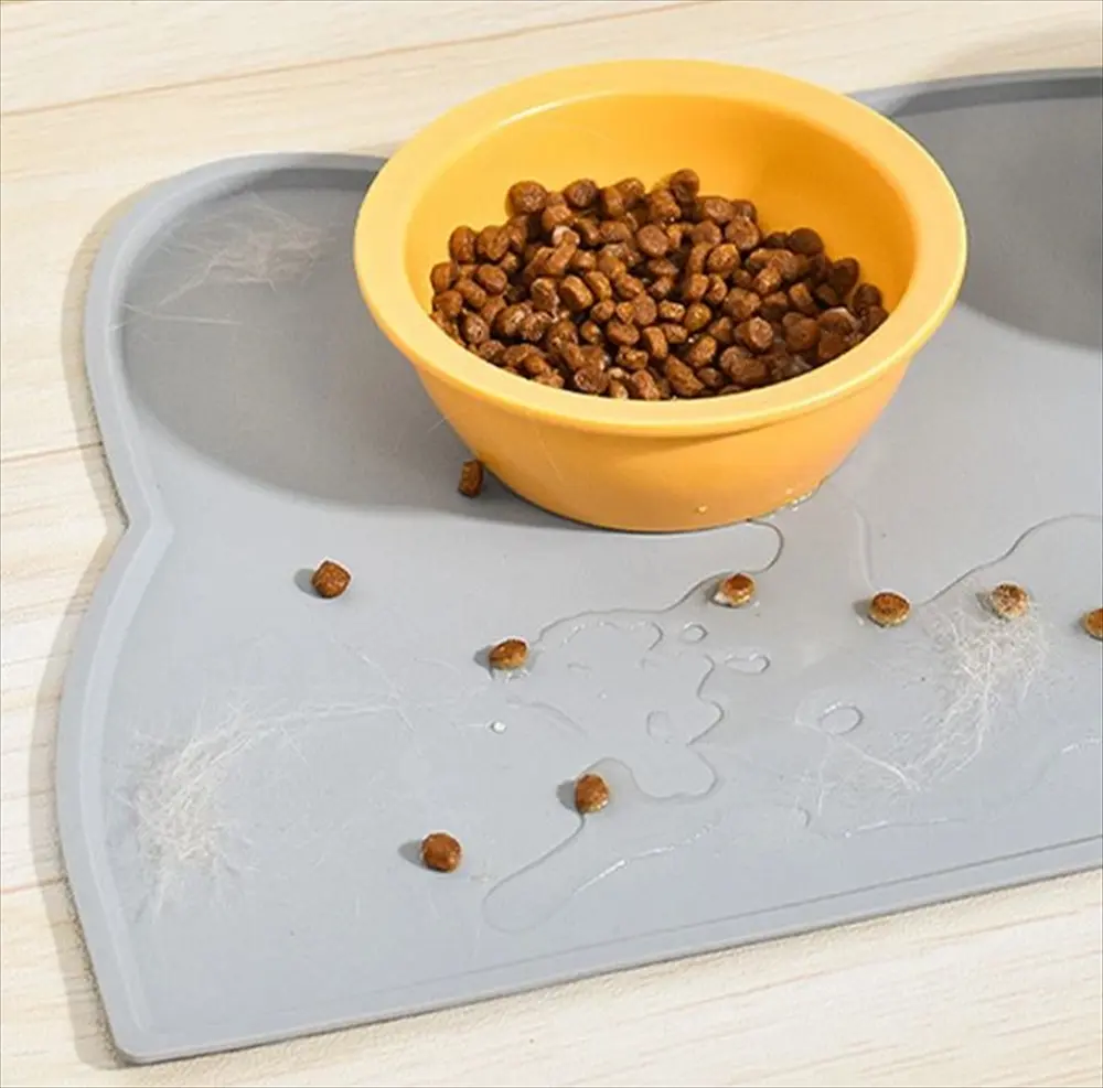 猫が食事マットの上でフードを食べているシーン