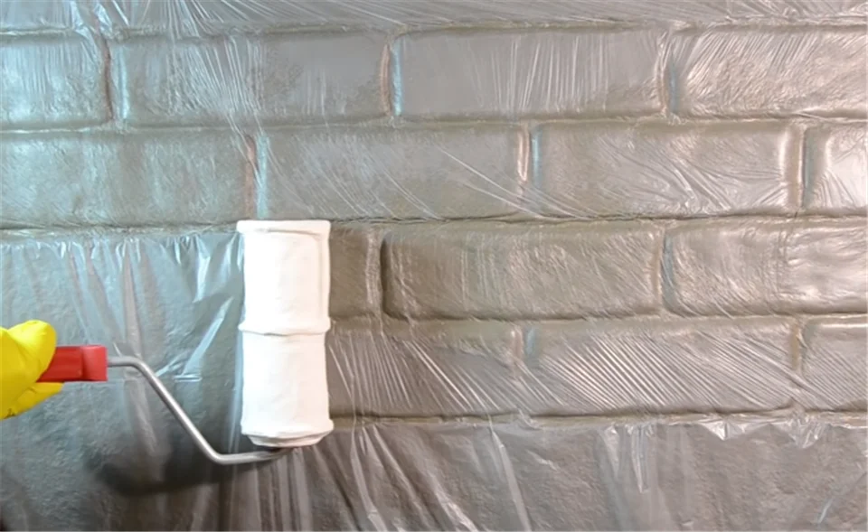 ローラーで壁面に塗装している様子