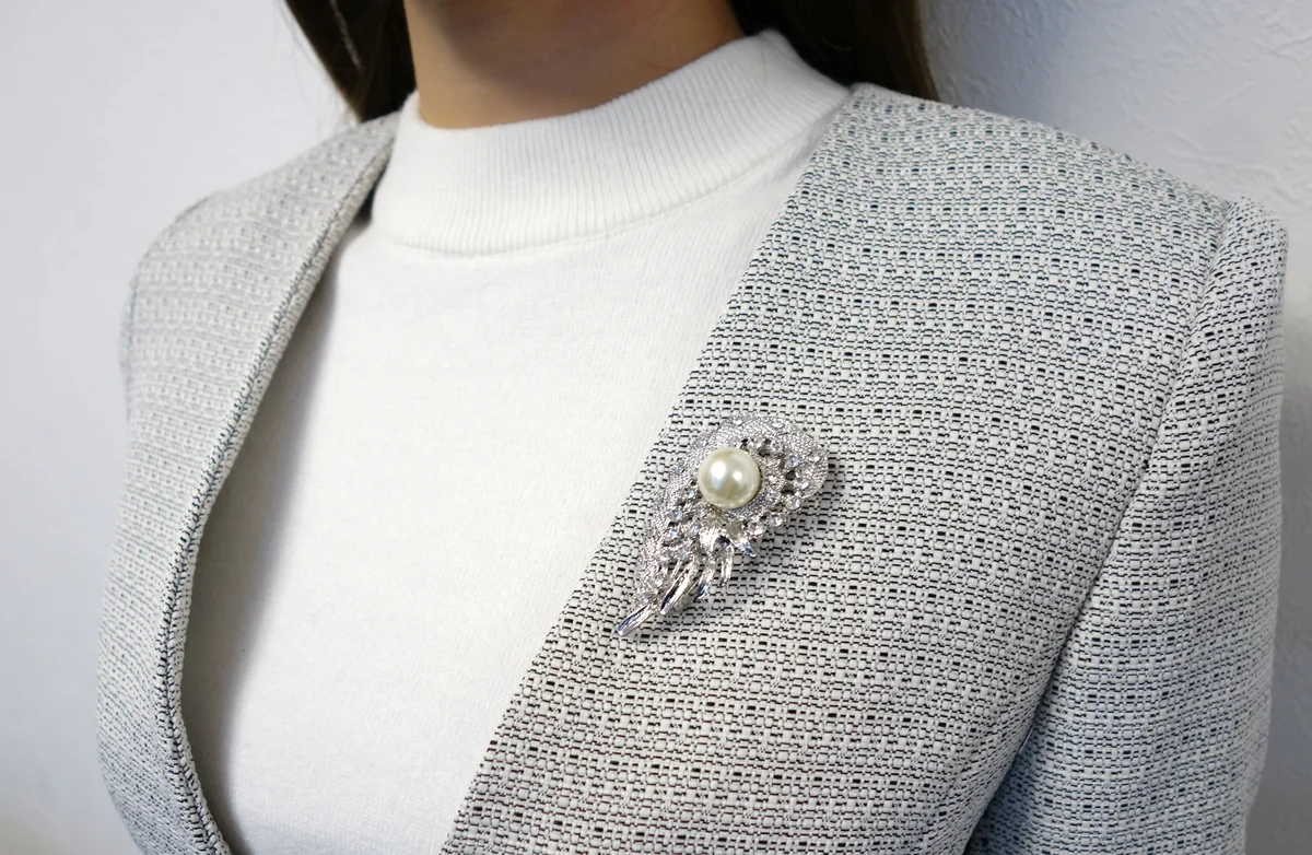 ブローチの着用アップ。パールとラインストーンの輝きが際立つ
