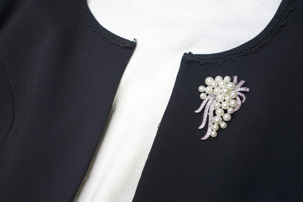 ネイビージャケットにパールブローチを着用したコーディネート例